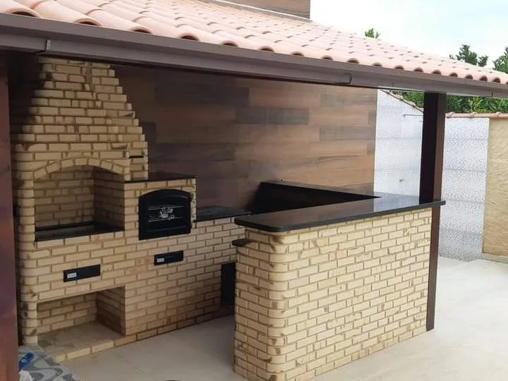 Área gourmet com churrasqueira e bancada em granito preto, obra da Mega